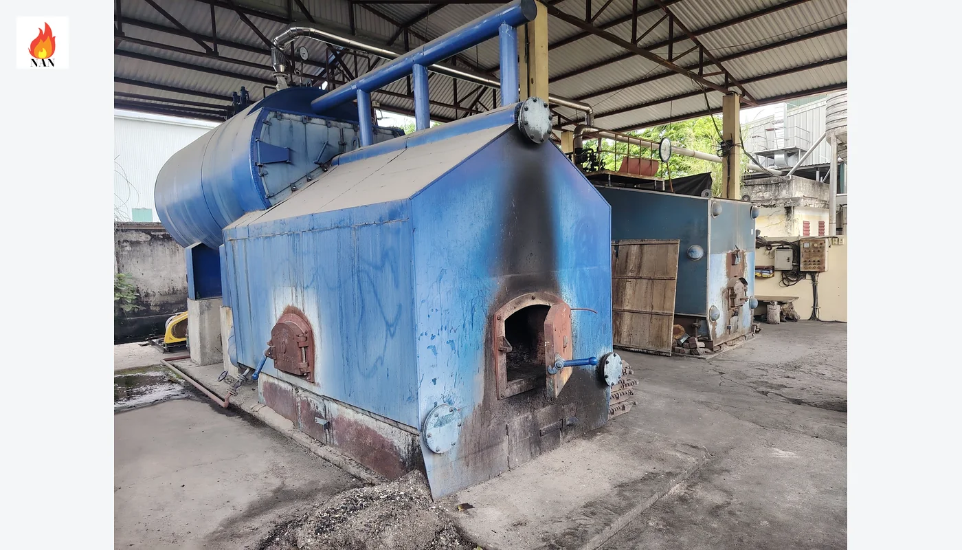 Hệ thống lò hơi công nghiệp với thân lò, đường ống và đồng hồ áp suất trong nhà lò.